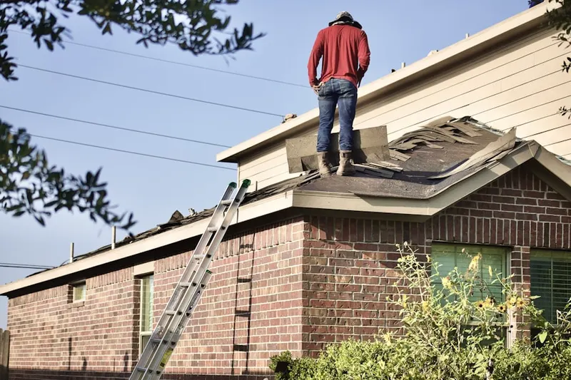 Professional roofer working on a residential roof in Americus